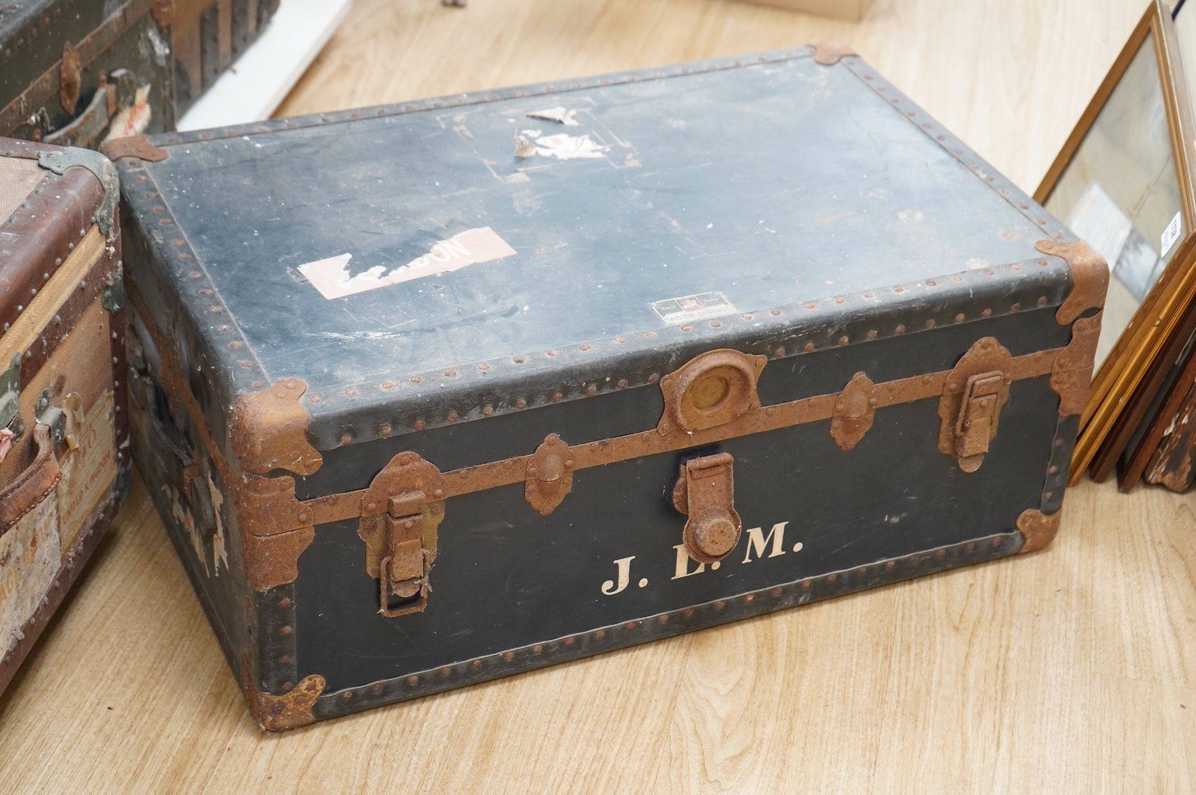 A collection of vintage luggage comprising four early 20th century bound travelling trunks and three kit bags